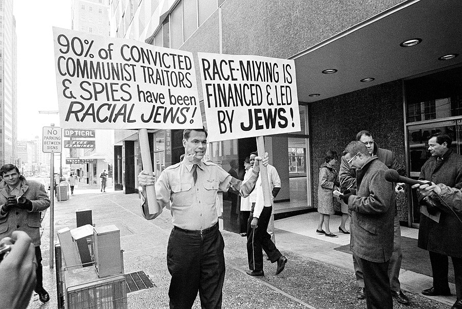 3 The American Nazi Party leader George Lincoln Rockwell carries placards as he picketed a building in Dallas on January 29, 1966, to test a city law against picketing by groups such as his - Fred Kaufman.jpg